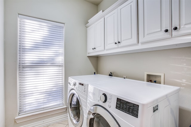 clothes washing area featuring cabinets and washer and clothes dryer