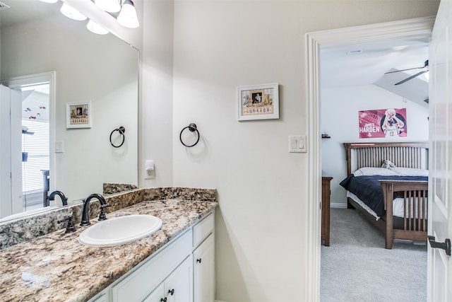 bathroom with vaulted ceiling, vanity, and ceiling fan