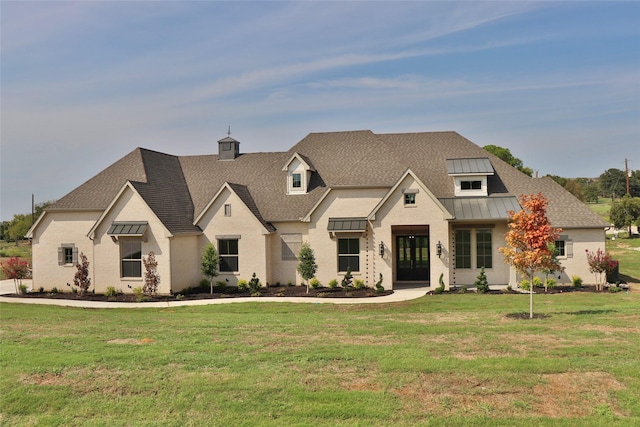 view of front of house with a shingled roof, a front yard, a standing seam roof, and metal roof