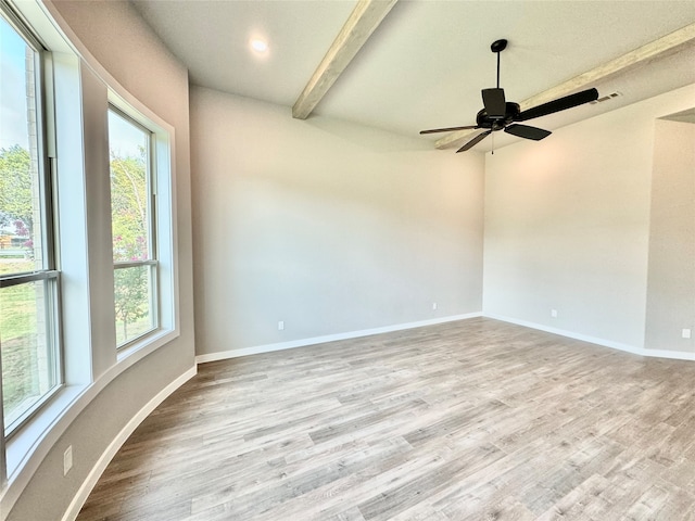 empty room with light wood-type flooring, beamed ceiling, a wealth of natural light, and ceiling fan