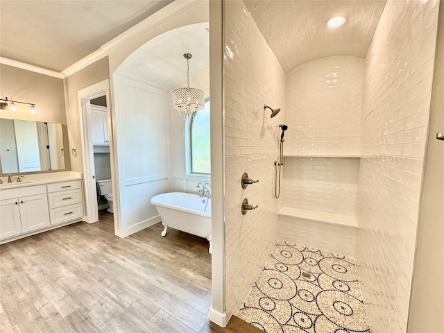 full bathroom featuring separate shower and tub, hardwood / wood-style floors, toilet, vanity, and ornamental molding