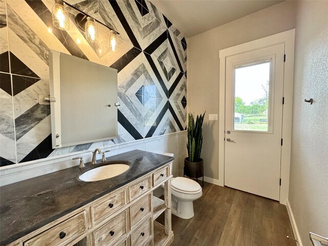 bathroom featuring toilet, hardwood / wood-style flooring, and vanity