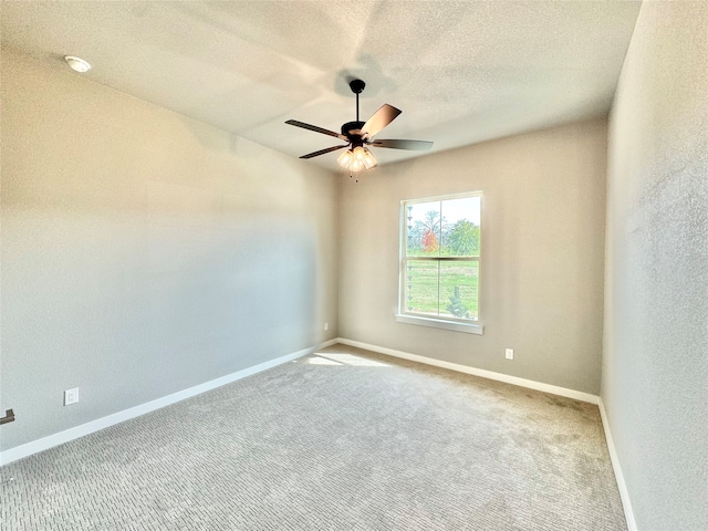 unfurnished room with a textured ceiling, ceiling fan, and carpet