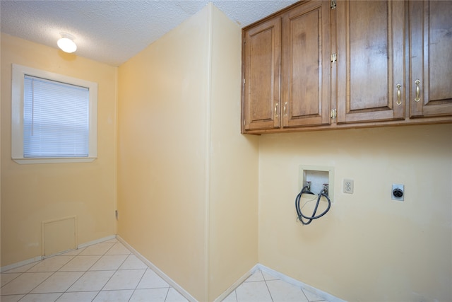 washroom with hookup for a washing machine, light tile patterned floors, hookup for an electric dryer, cabinets, and a textured ceiling