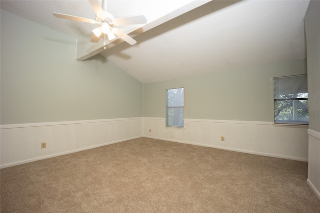 spare room featuring a textured ceiling, ceiling fan, carpet floors, and lofted ceiling with skylight