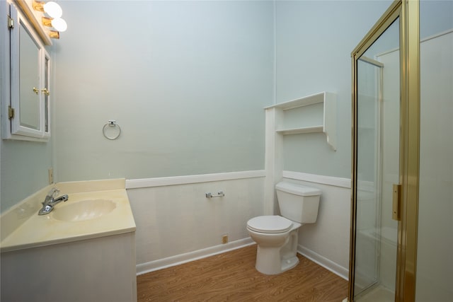 bathroom with vanity, toilet, hardwood / wood-style flooring, and a shower with shower door