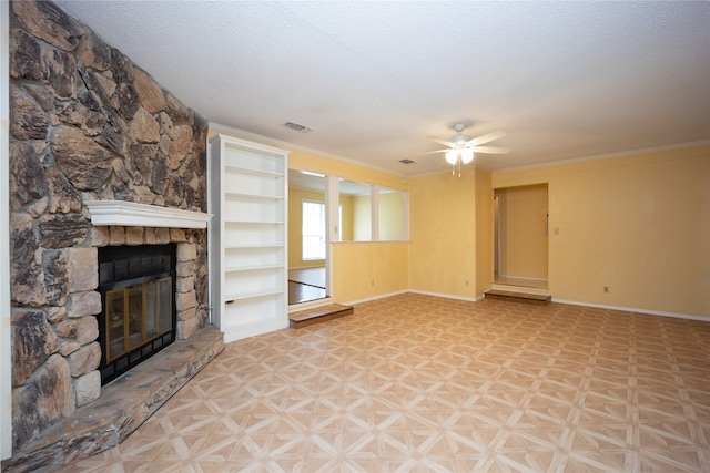 unfurnished living room with light parquet floors, a textured ceiling, ceiling fan, and a stone fireplace