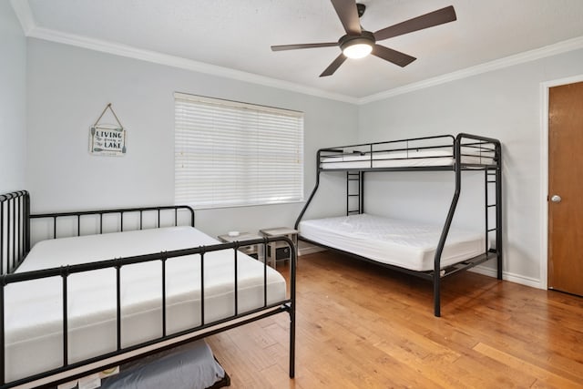 bedroom featuring ornamental molding, light wood-type flooring, and ceiling fan