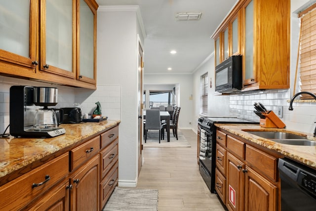 kitchen featuring sink, light hardwood / wood-style flooring, black appliances, backsplash, and ornamental molding