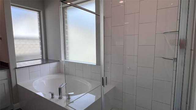 bathroom featuring separate shower and tub and a healthy amount of sunlight