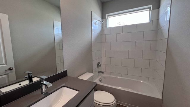 full bathroom with tiled shower / bath, vanity, and toilet