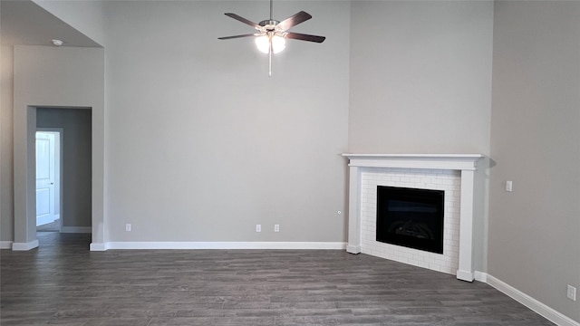 unfurnished living room with ceiling fan, dark wood-type flooring, and a fireplace