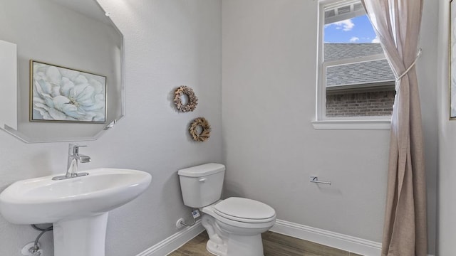 bathroom with toilet, sink, and hardwood / wood-style flooring