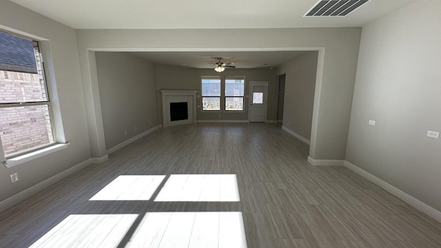 unfurnished living room with dark wood-type flooring and ceiling fan