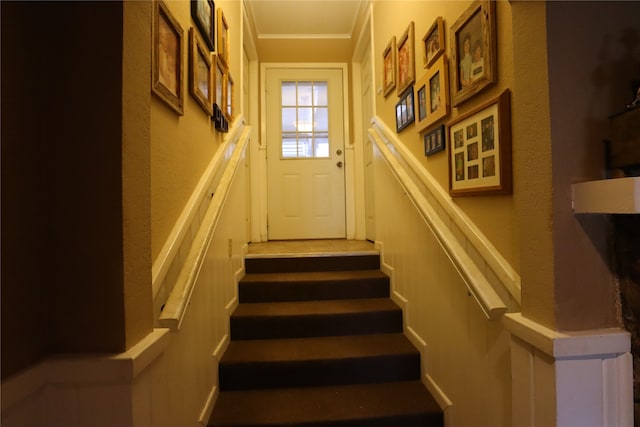 stairway featuring ornamental molding