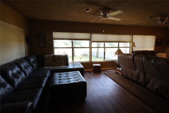 living room with a textured ceiling, wood-type flooring, and ceiling fan