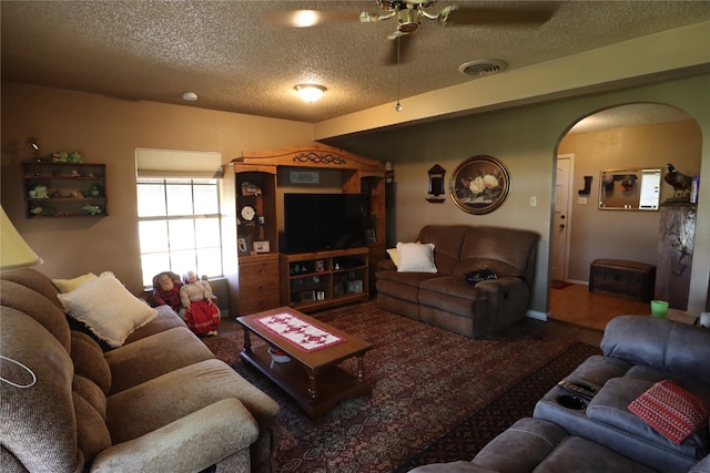 living room with ceiling fan, a textured ceiling, and hardwood / wood-style floors