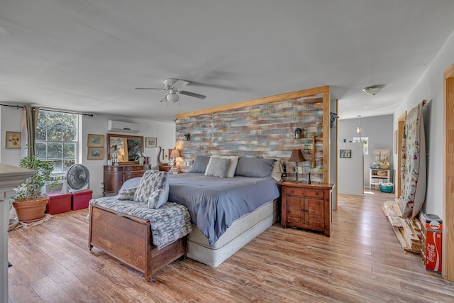 bedroom featuring an AC wall unit, ceiling fan, and light hardwood / wood-style flooring