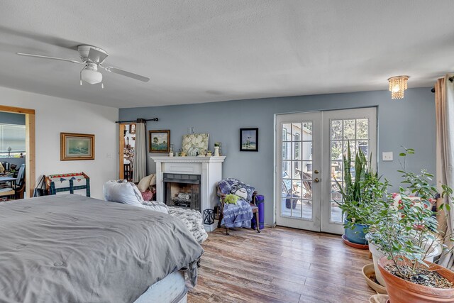 bedroom with ceiling fan, french doors, a textured ceiling, light wood-type flooring, and access to exterior