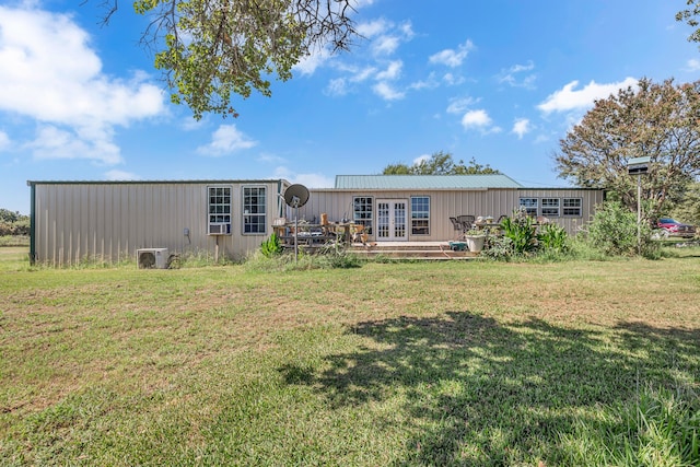 rear view of house featuring french doors and a yard