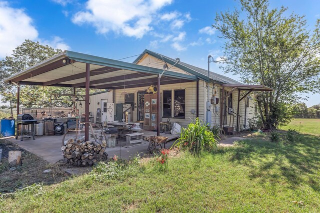 back of property with a yard and a patio area