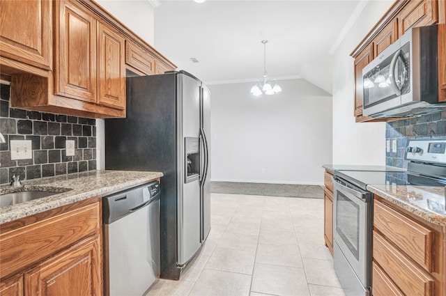 kitchen featuring ornamental molding, a chandelier, light stone countertops, decorative backsplash, and appliances with stainless steel finishes