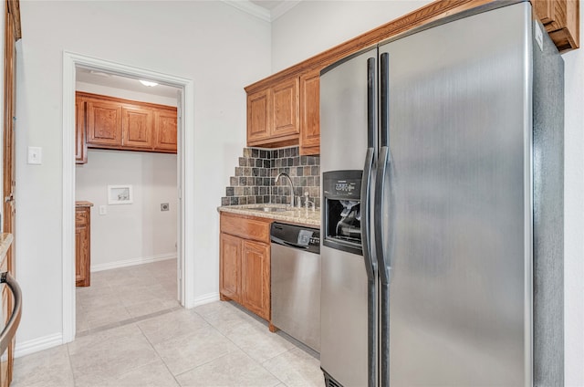 kitchen featuring light stone countertops, stainless steel appliances, sink, light tile patterned flooring, and ornamental molding