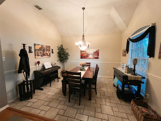 dining space featuring lofted ceiling, a notable chandelier, and a textured ceiling