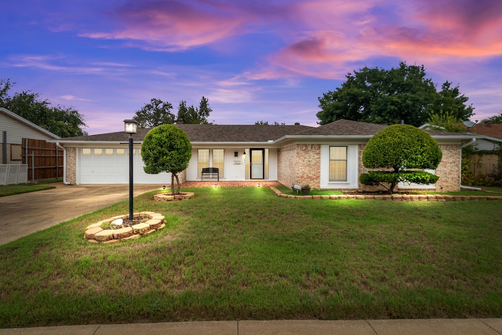 ranch-style home featuring a yard and a garage