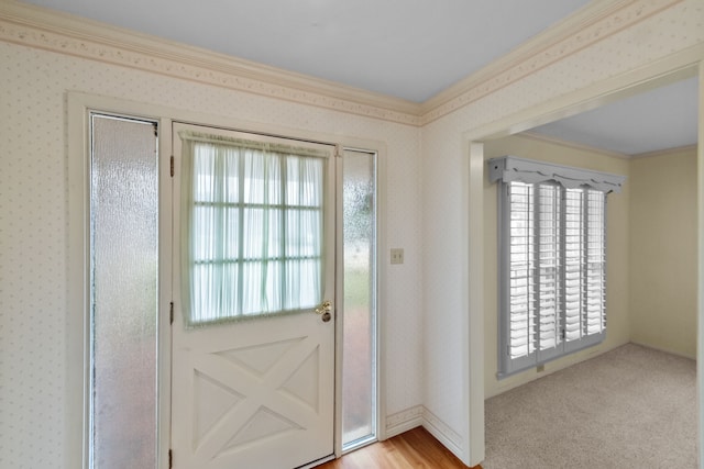 doorway featuring light carpet, ornamental molding, and a wealth of natural light