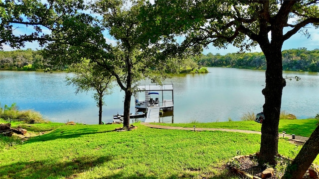 view of dock with a water view and a lawn