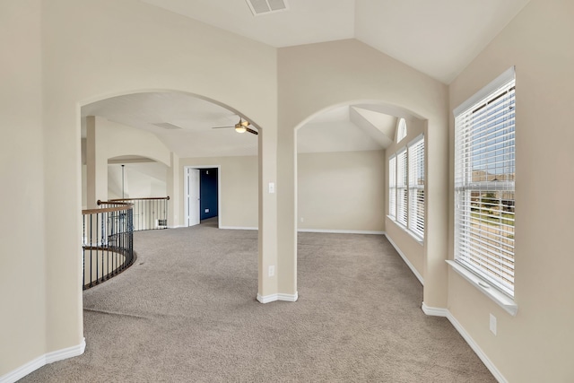 carpeted empty room featuring vaulted ceiling and ceiling fan