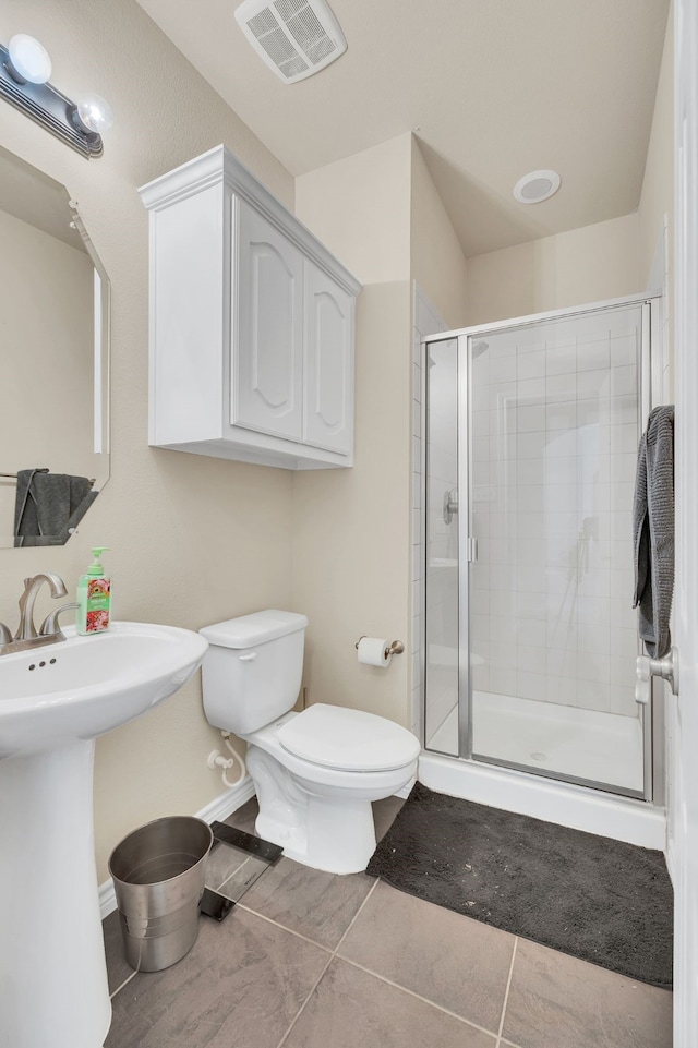 bathroom with toilet, tile patterned floors, and an enclosed shower