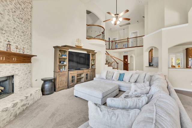 carpeted living room featuring a towering ceiling and ceiling fan