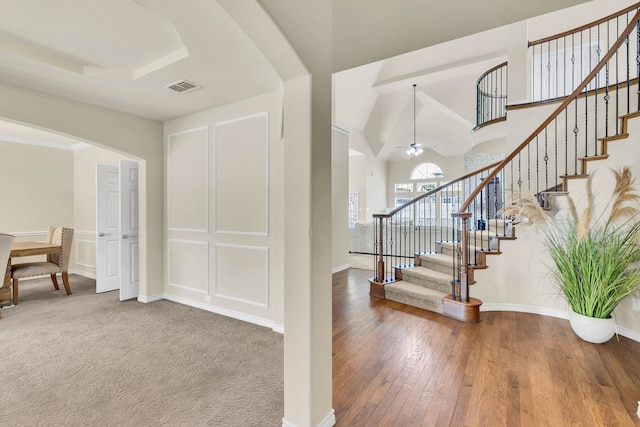 foyer with ceiling fan, lofted ceiling, and carpet