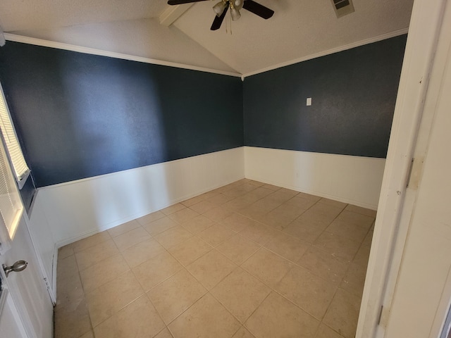 tiled empty room featuring ceiling fan, crown molding, lofted ceiling with beams, and a textured ceiling