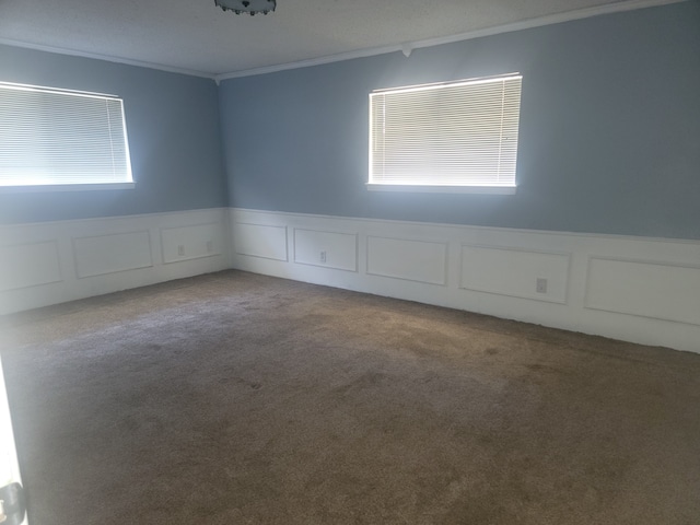 carpeted empty room featuring a wealth of natural light and crown molding