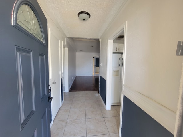 hallway with light tile patterned floors and a textured ceiling