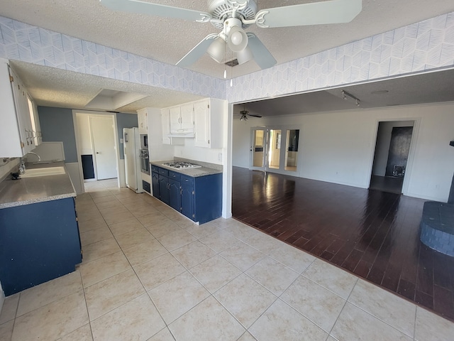 kitchen featuring light hardwood / wood-style flooring, blue cabinetry, sink, ceiling fan, and white cabinets