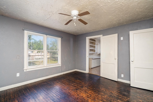 interior space featuring a textured ceiling, dark wood-type flooring, and ceiling fan