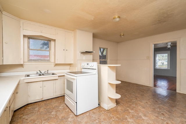 kitchen with ceiling fan, sink, white range with electric cooktop, and white cabinetry