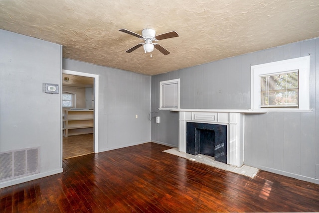 unfurnished living room featuring ceiling fan, hardwood / wood-style flooring, and a textured ceiling