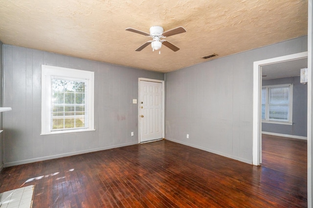 interior space with dark hardwood / wood-style flooring, ceiling fan, and a textured ceiling