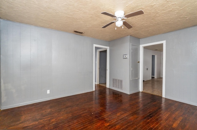 unfurnished room with a textured ceiling, dark wood-type flooring, and ceiling fan