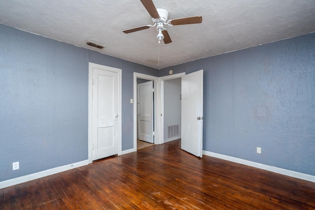 unfurnished bedroom with a textured ceiling, ceiling fan, and dark hardwood / wood-style flooring