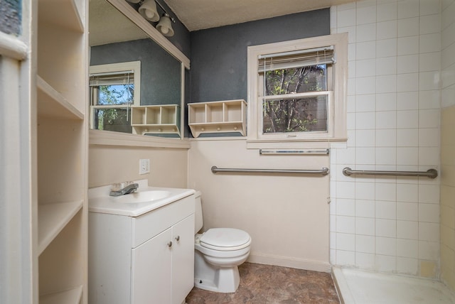 bathroom with a tile shower, toilet, a wealth of natural light, and vanity