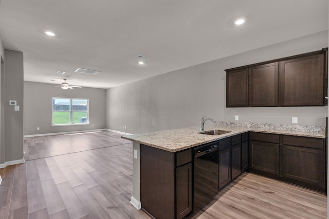 kitchen with black dishwasher, sink, ceiling fan, light stone counters, and light wood-type flooring