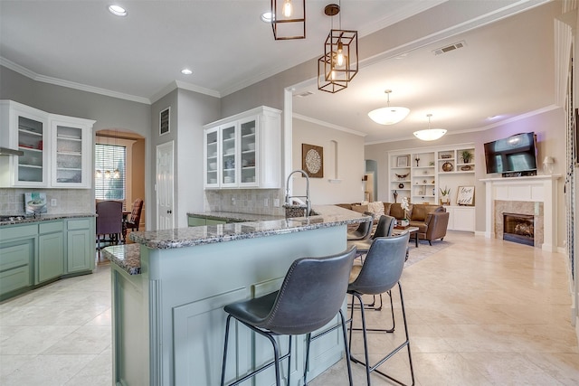 kitchen featuring decorative backsplash, white cabinetry, pendant lighting, and built in features