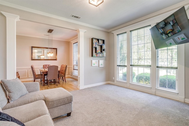 living room with ornamental molding, a wealth of natural light, and decorative columns