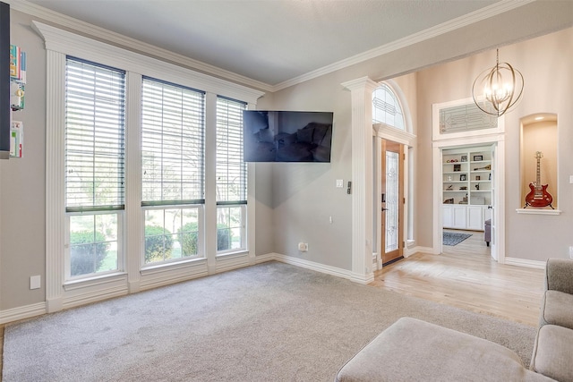 interior space with crown molding, a chandelier, wood-type flooring, and a wealth of natural light